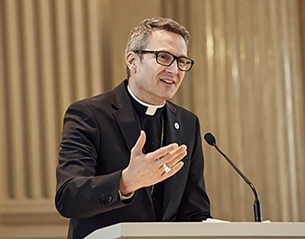 Bishop Hicks speaking at a podium